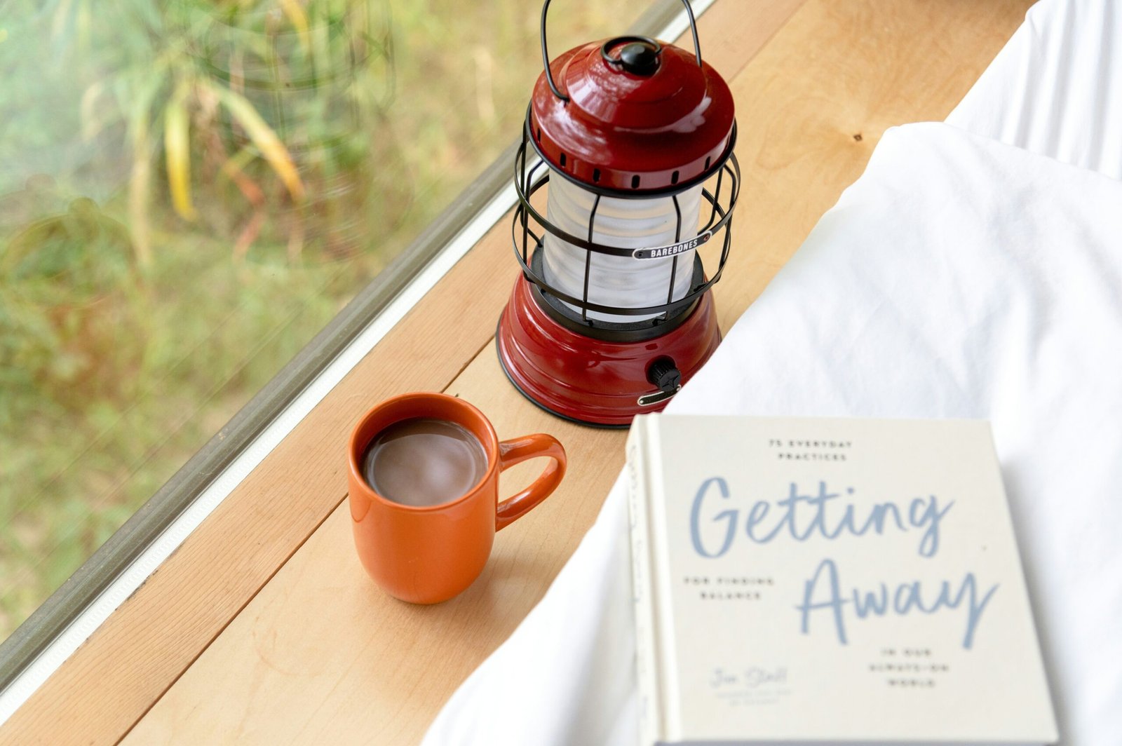 A person writing in a notebook next to a cup of tea