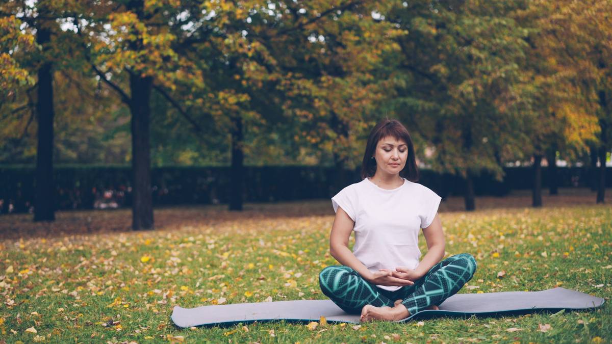 A woman practicing yoga near candles and acupuncture supplies.